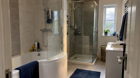 Bath with overhead shower beside separate enclosure