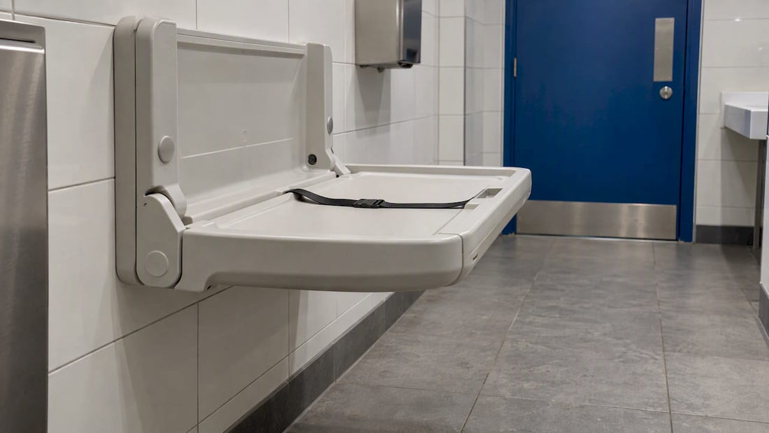 Fold-down baby changing table in a commercial washroom